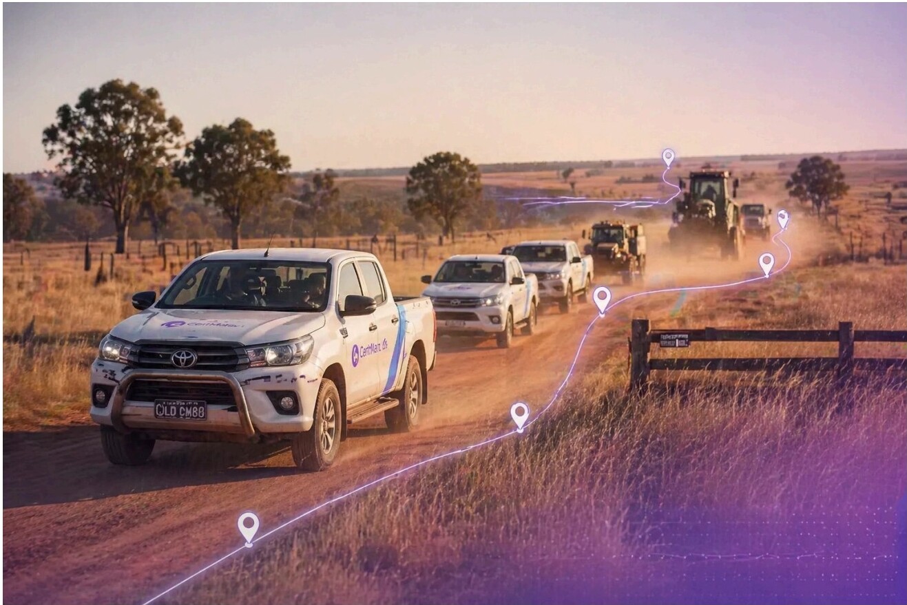 Convoy of utility vehicles on a rural dirt road with digital location markers overlaid